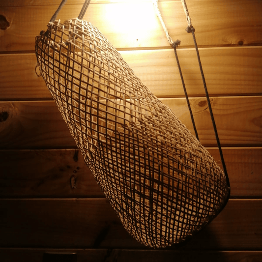 Bolso Jimbaran de rafia estilo boho, colgado en un muro