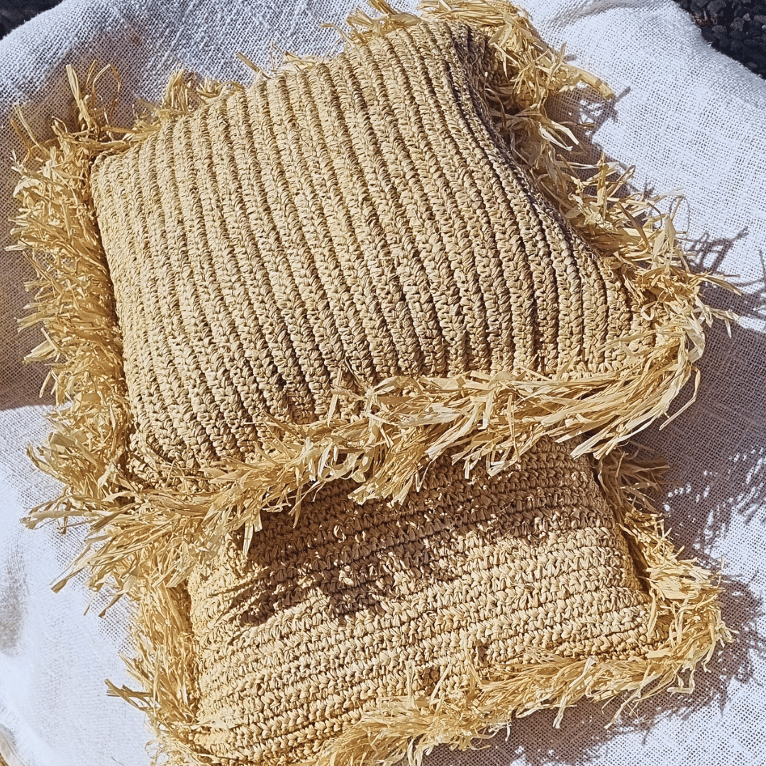 Cojínes Balangan cuadrados sobre sillón.