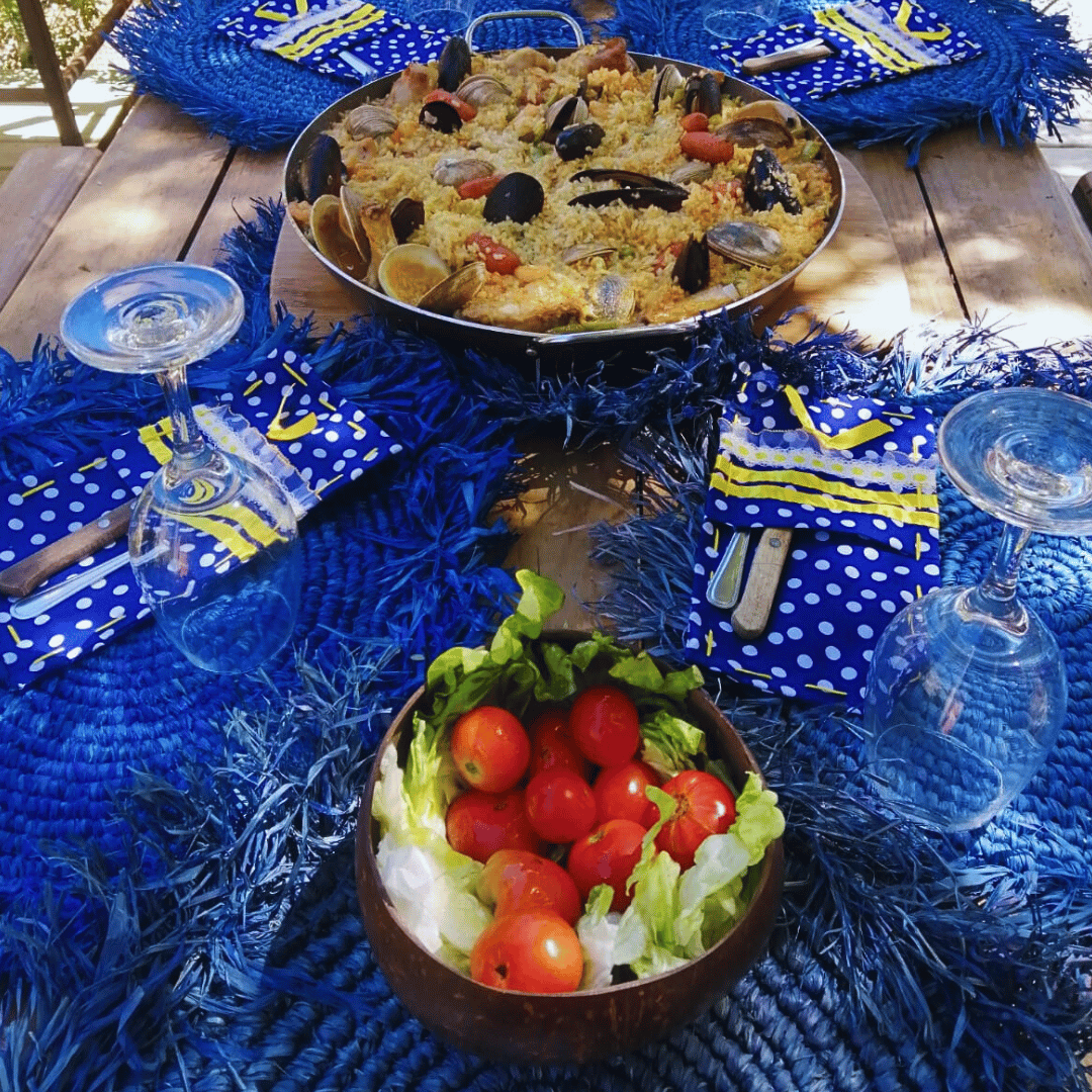 Mesa decorada con individuales redondos de rafia azules para almorzar