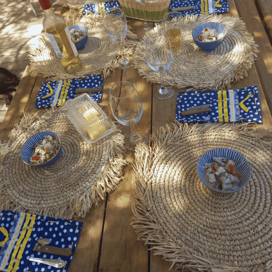 Mesa decorada con individuales redondos de rafia para almuerzo