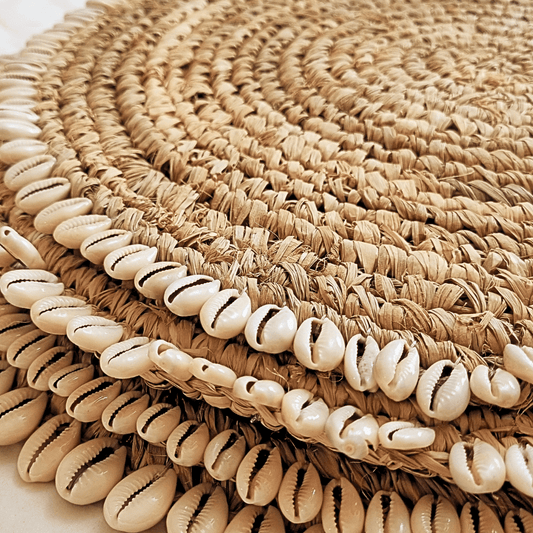 Detalle de conchitas marinas en individual de rafia tejido.