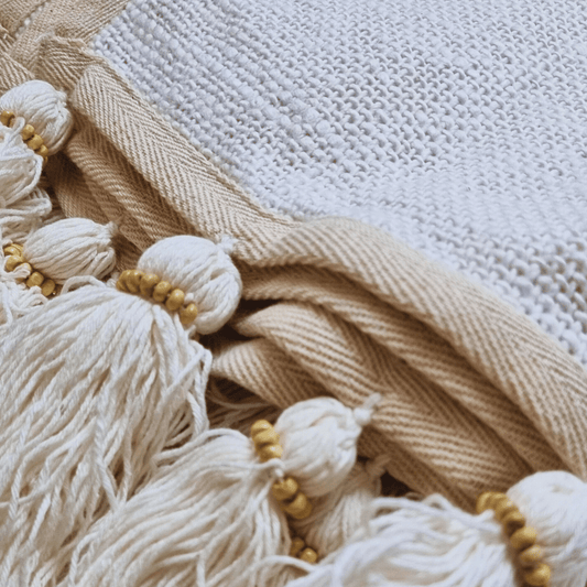 Manta Medan de algodón grande estilo boho sobre cama.