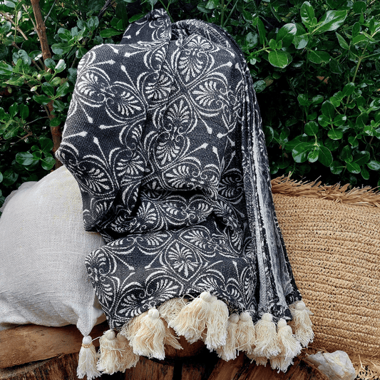 Manta Nihiwatu de algodón grande tejida a mano en Bali estilo boho sobre sofa.