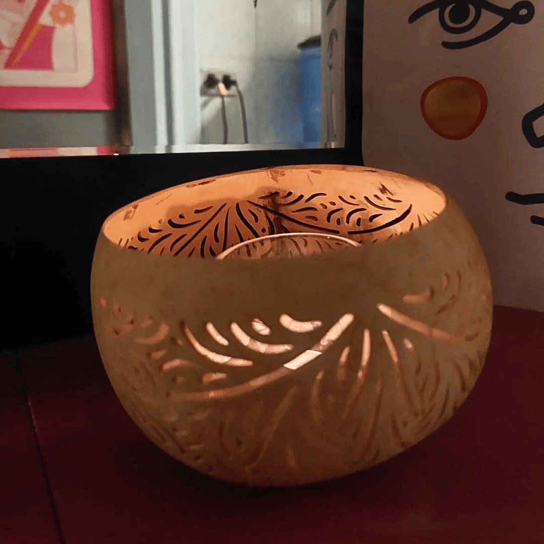 Portavela de coco artesanal con patrón tribal tallado.