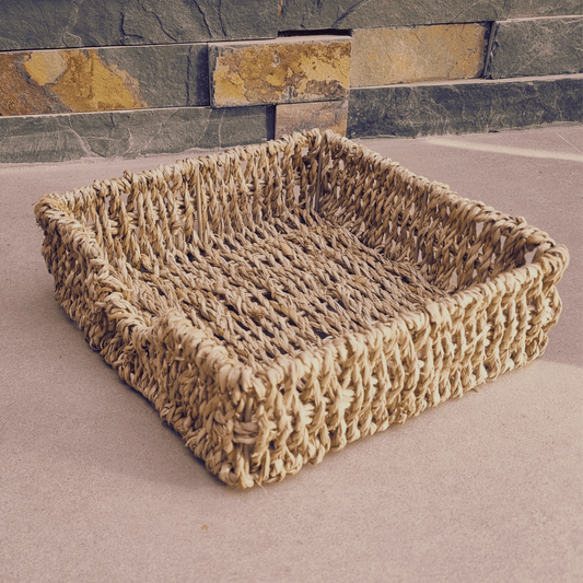 Servilletero Cu Chi de fibra natural seagrass con servilletas de tela sobre mesa