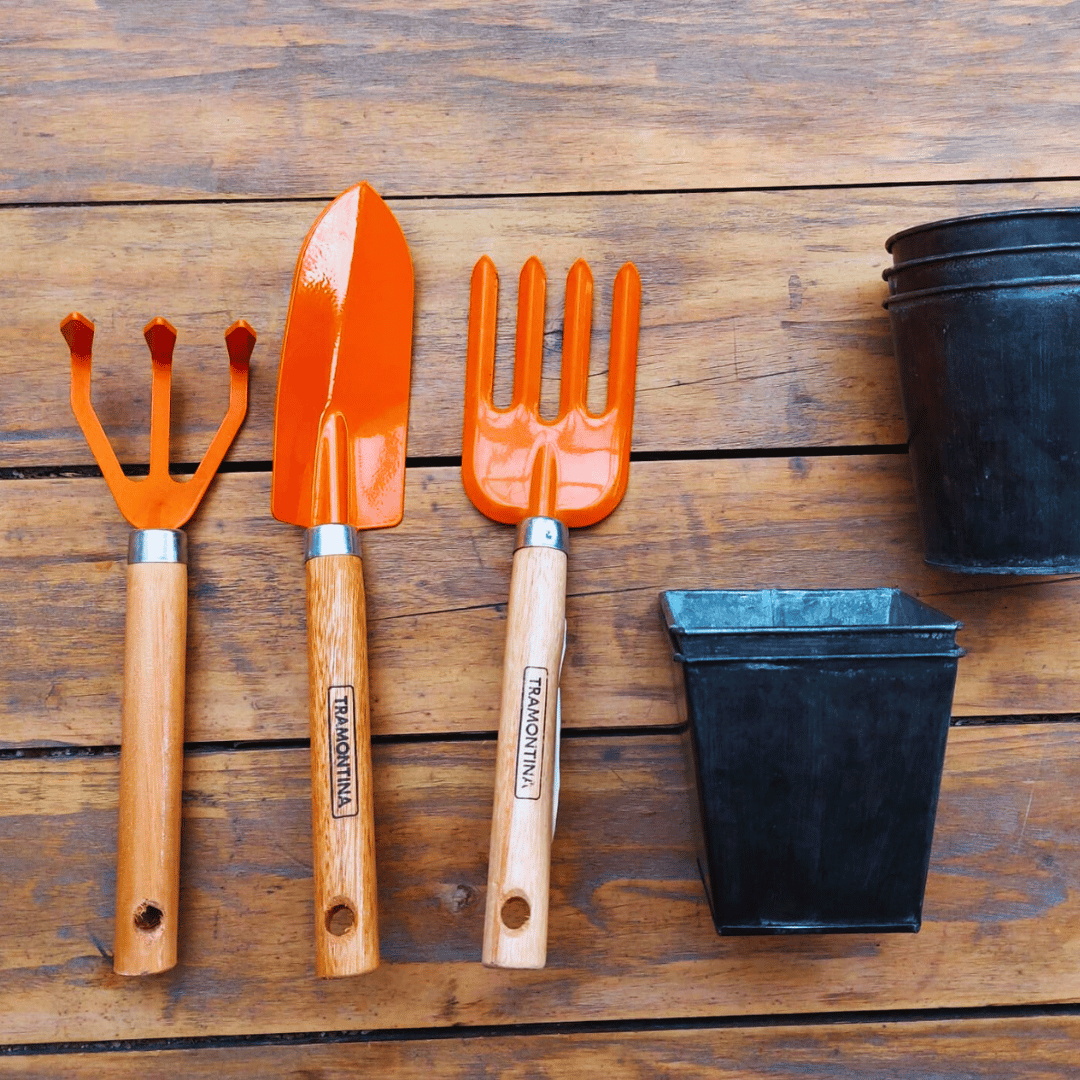 Herramientas de jardinería, hechas de acero y mango de madera, con maceteros metálicos pequeños.